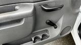 Close-up of the interior door handle and manual window crank of a 2013 Chevrolet Silverado 1500 with a textured gray finish and a cup holder inset