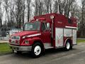 A 1995 Freightliner FL70 fire rescue truck in red with a white stripe and rescue markings on the side