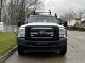 A 2015 Ford F-550 truck in front view with a black grille orange lights on top and a rugged appearance