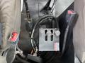 The interior of a 2013 Kenworth T370 featuring a floor-mounted gear shift lever a wiring harness and control panel with switches
