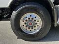 Close-up of a Michelin tire on a 2005 Volvo VND 122 featuring a shiny metal rim with multiple holes for bolts and the tire size markings 425 65 R 22.5