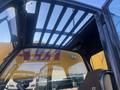 Interior view of a 2013 JCB 510-56 Loadall cab featuring a safety grill on the roof and a control panel with levers and seating