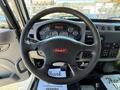 The interior view of a 2019 Peterbilt 337 truck showing a black steering wheel with the Peterbilt logo and a dashboard with various gauges and controls