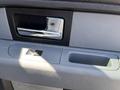 Close-up of the interior door handle and armrest of a 2014 Ford F-150 showcasing the metallic handle and storage compartment