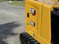 A yellow Caterpillar 306 excavator with visible branding and model number on the side of the machine