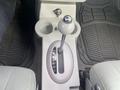 Close-up of a 2007 Chrysler PT Cruiser's gear shift and center console featuring cup holders and gear selection indicators on a gray interior