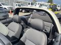 Interior view of a 2005 Chrysler PT Cruiser showing two front seats with headrests and an open convertible top