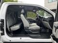 Interior of a 2017 Ford F-250 showing front and rear seats upholstered in grey fabric with black accents and ample legroom