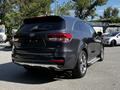 A 2017 Kia Sorento in dark gray color positioned at an angle showing the rear and side view with chrome accents and a roof spoiler