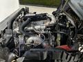 An open engine compartment of a 2020 Hino 155 showcasing the engine components including pipes valves and various mechanical parts