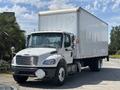 A 2015 Freightliner M2 106 box truck with a white exterior and large cargo area stands parked with its front facing forward