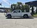 A white 2011 Chevrolet Colorado pickup truck parked with palm trees in the background