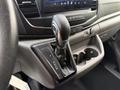 The gear shifter of a 2022 Ford Transit featuring a leather-wrapped handle with markings for park reverse neutral drive and manual modes