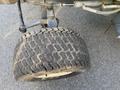 A close-up view of a large, rugged tire from a 2010 Kubota F3680 with a deep tread pattern designed for traction on various surfaces