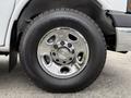 Close-up of a chrome wheel with a Chevrolet logo mounted on a 2013 Chevrolet Express tire with a rugged tread pattern