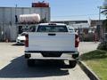 A white 2021 Chevrolet Silverado 1500 pickup truck viewed from the rear with a chrome bumper and tailgate featuring the Chevrolet logo