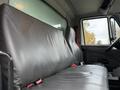 Interior view of a 2011 International 4400 truck featuring a black leather bench seat with two individual seats and a seatbelt on the right side