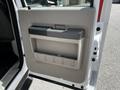 Interior door panel of a 2009 Ford F-550 featuring a handle and storage compartment in a neutral color scheme