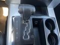 The gear shifter of a 2011 RAM 1500 positioned in the center console with options for park reverse neutral drive and a storage area for cups