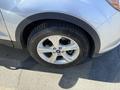 A close-up view of a silver 2014 Ford Escape's wheel showing alloy rims and tire tread