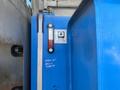 A blue hydraulic tank of a 1997 Genie S-65 4X4 with a fluid level gauge and a label indicating designated ATF usage