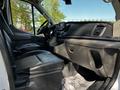Interior view of a 2021 Ford Transit showcasing leather seats a dashboard with a touchscreen and various controls