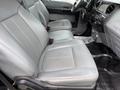 Interior view of a 2015 Ford F-350 SD showing two front seats with gray upholstery and a dashboard with controls and an audio system