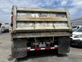 A 2013 K-Line 16 foot steel tandem pony 17 ton dump trailer with Air Weigh displaying a weathered appearance and visible wear on the tailgate and wheels