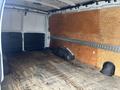 Interior of a 2022 GMC Savana cargo van with wooden flooring and walls lined with plywood panels