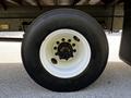 A close-up view of a white rim with a black tire marked with Bridgestone on a 2021 Hino 338 truck