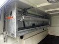 A silver metal shelving unit with two metal rods is mounted inside the cargo area of a 2017 Ford F-150