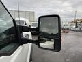 A 2013 Ford F-350 SD side mirror reflecting a vehicle with a clear view of the mirror's dual glass surfaces