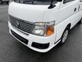 A white 2002 Nissan Van featuring a prominent front grille headlights and a simple design