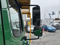 A green 2015 Freightliner M2 106 truck with a large side mirror visible in the foreground