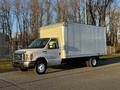A 2017 Ford Econoline with a box truck body parked on the street