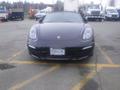 A 2016 Porsche Boxster in black with distinctive round headlights and a sleek front design parked on a lot with visible license plate 338 LMC