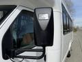 A 2010 Ford Econoline with a close-up view of its side mirror featuring a sleek design and the brand logo