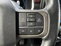 Close-up of the steering wheel controls of a 2021 Ford F-150 featuring buttons for back menu ok and phone functions