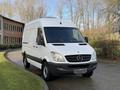 A 2012 Mercedes-Benz Sprinter van with a white exterior and front passenger doors visible