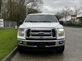 Front view of a white 2017 Ford F-150 with a prominent grille and headlights parked on the street