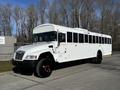 A white 2022 Blue Bird Vision school bus with black wheels and windows parked on a street