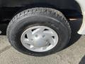 A close-up of a tire mounted on a silver wheel showing the tread pattern and the Ford logo on the center cap