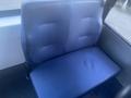 A blue padded seat from a 2017 Chevrolet Express van with a smooth surface and minimal detailing