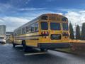 2005 Blue Bird 48 passenger yellow school bus facing away with large windows and rear lights visible