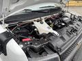 Engine compartment of a 2020 Chevrolet Express showing the engine block various hoses and components along with a white coolant reservoir