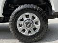 Close-up of a silver rim with a heavy-duty tire on a 2017 Ford F-250 SD showcasing intricate designs on the wheel and deep tread patterns on the tire