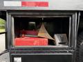 A storage compartment of a 2011 International 4300 truck containing red toolboxes a yellow wedge and a gray block
