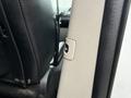 A close-up view of the interior of a 2017 Dodge Grand Caravan showing the seat adjustment lever on the side of a black leather seat