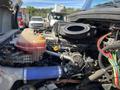 A close-up view of the engine compartment of a 2022 Freightliner Cascadia showing various hoses and components including a coolant reservoir and air intake system