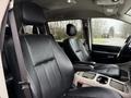 Interior view of a 2017 Dodge Grand Caravan showing two front seats with black leather upholstery and a center console